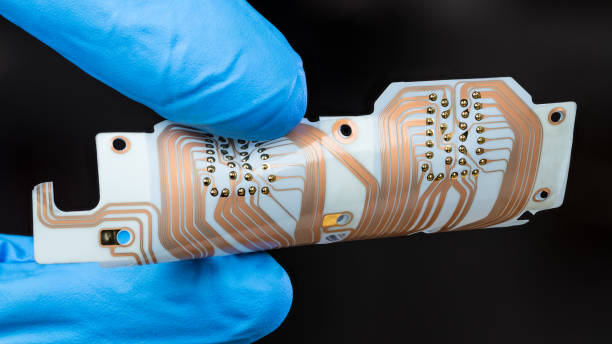 PCB a medida con forma personalizada mostrando pistas de cobre y vías sujetado con guante de laboratorio